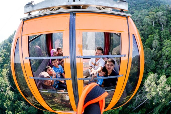 A photo of a private group inside the cable car, with the guide gesturing toward the scenic views outside.