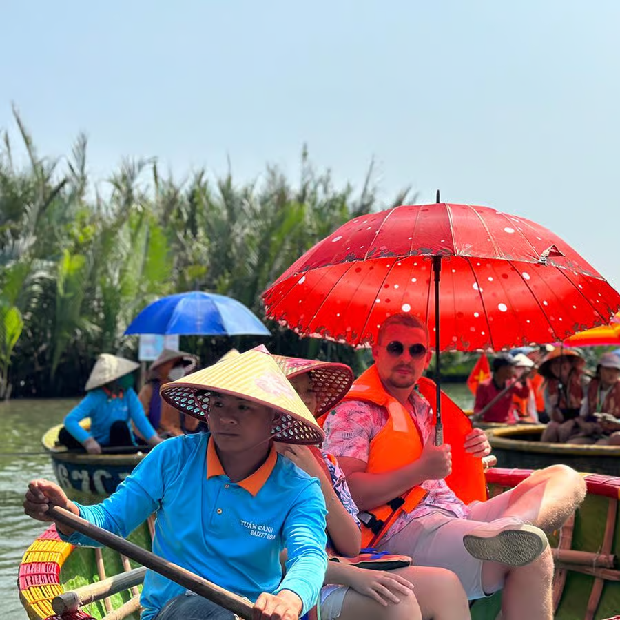 Tour guide at Cam Thanh dock with bamboo basket boats, starting the best coconut boat tour in Cam Thanh Village, Hội An, for an eco-friendly adventure.