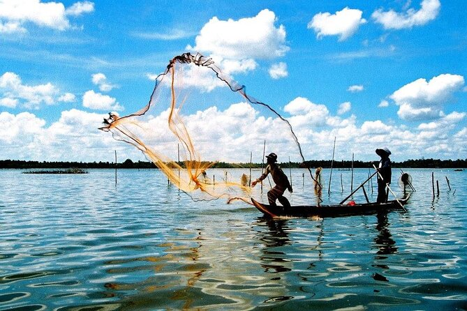 Local fisherman casting a net on the Cua Dai River during the best coconut boat tour in Cam Thanh Village, Hội An, highlighting cultural heritage